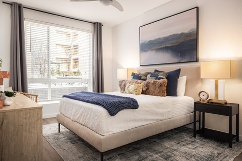 a bedroom with a bed and a large window