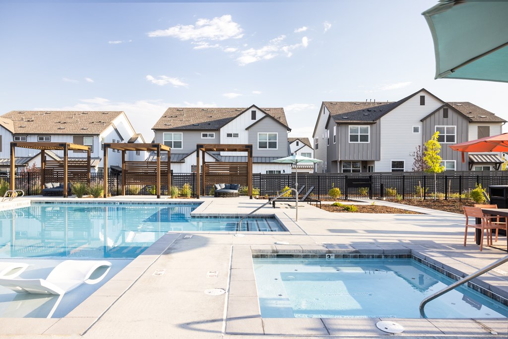A swimming pool surrounded by a fence and a bench.