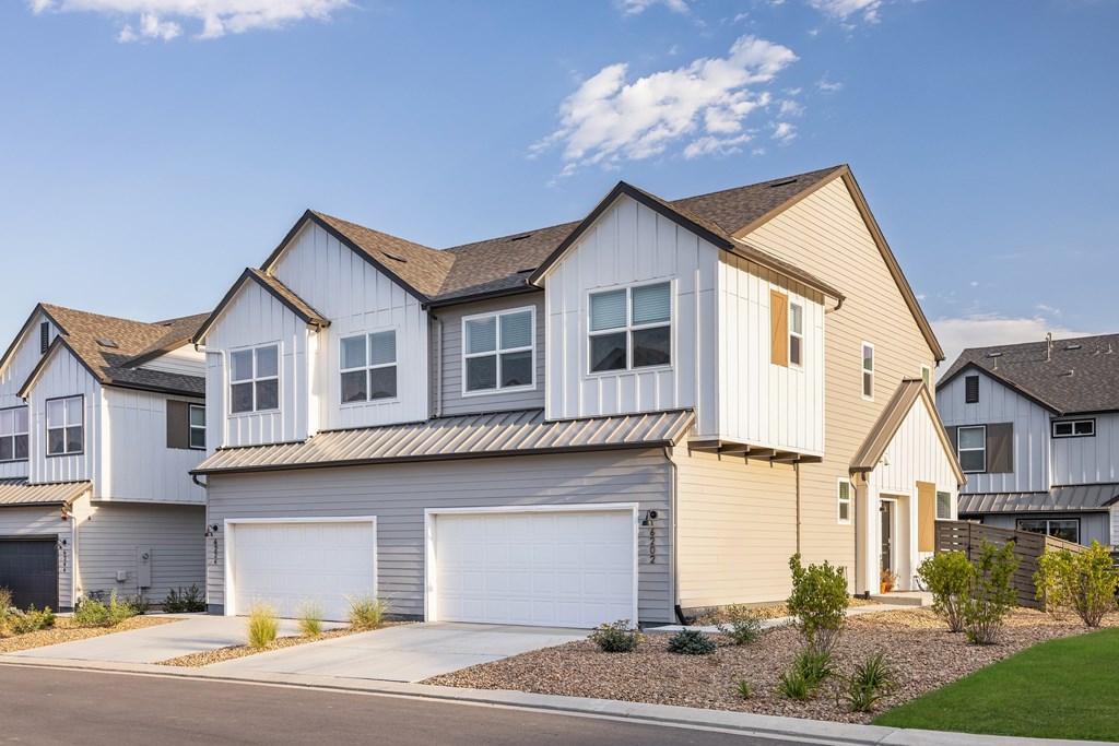 A modern house with a white garage door is shown.