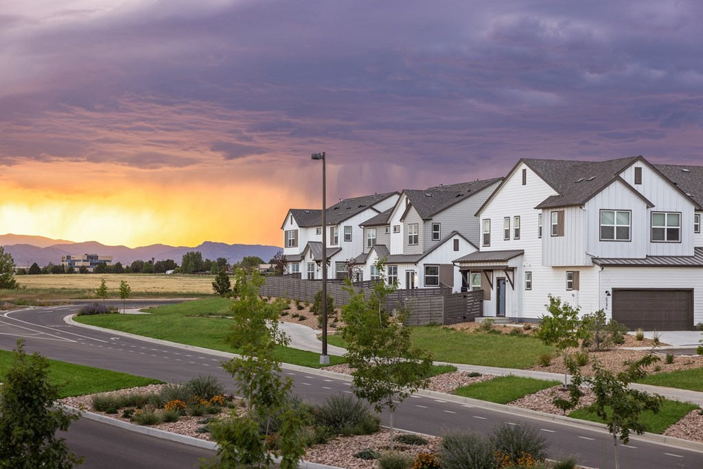 A row of houses with a street in front of them.