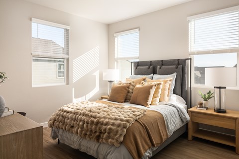 A bedroom with a large bed and a wooden nightstand.