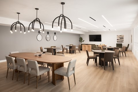 A modern dining room with a large table and chairs.