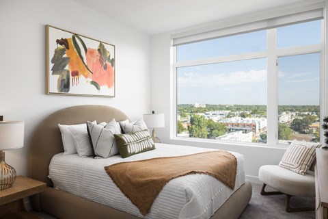 A bedroom with a large bed and a view of the city.
