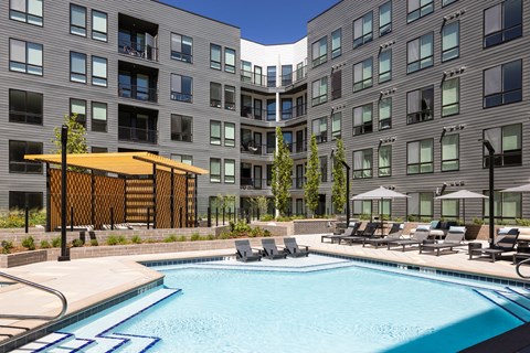 a swimming pool in front of a large apartment building