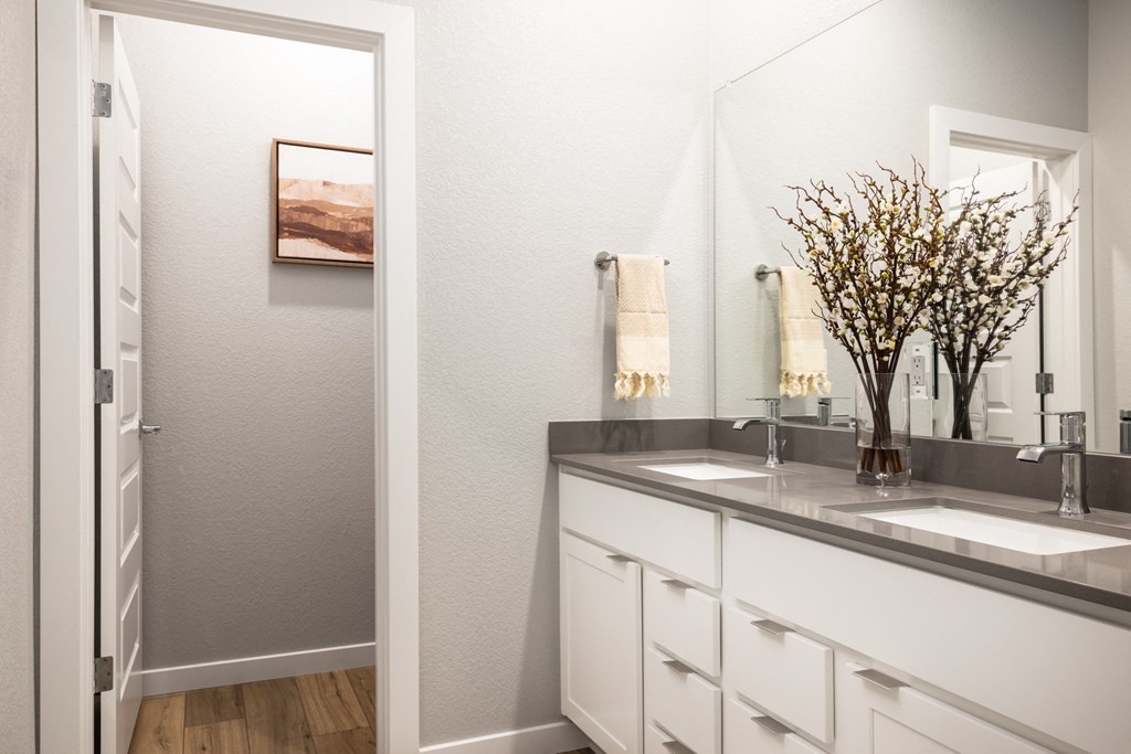 a bathroom with white cabinets and a sink and a mirror