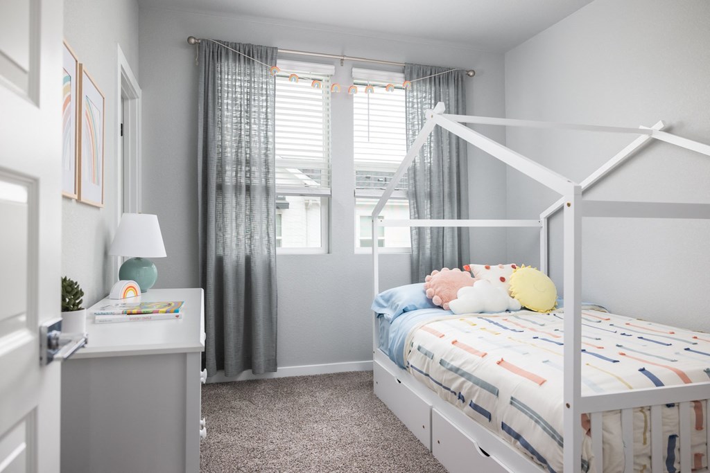 a bedroom with a white bunk bed and gray walls and a window