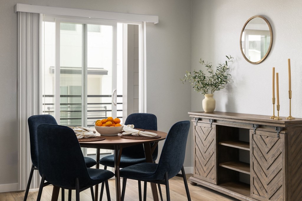 a dining room with a table with a bowl of oranges on it