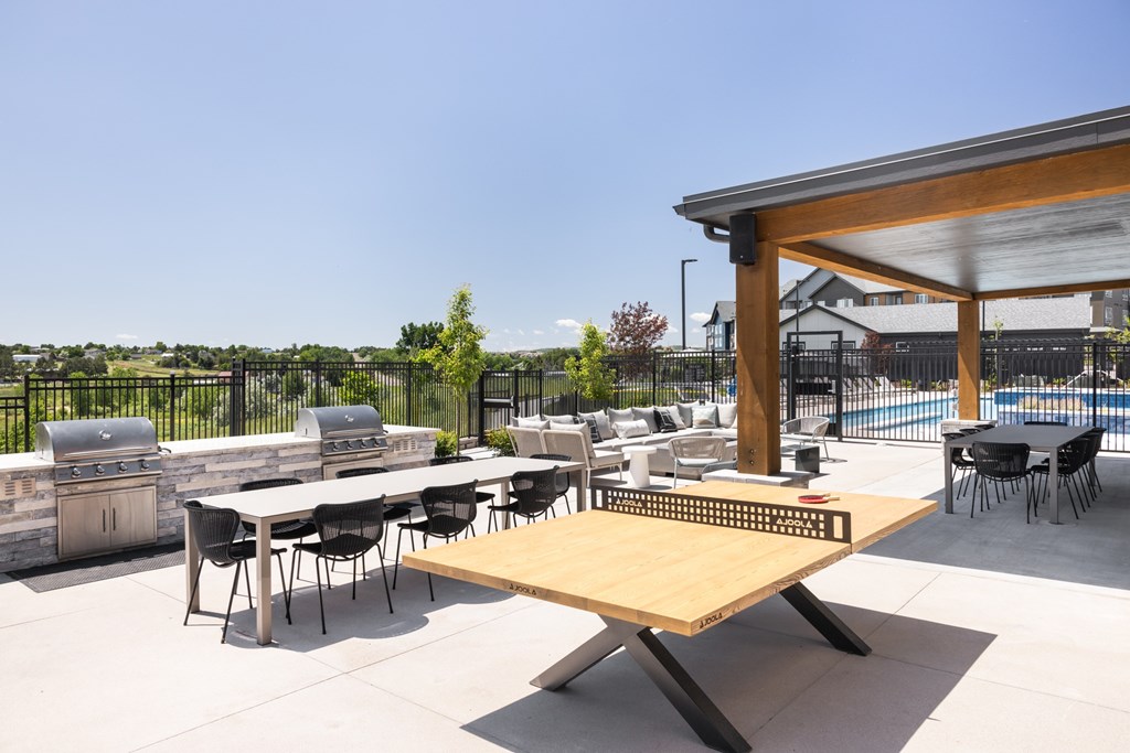 A table tennis table is in the middle of an outdoor patio.