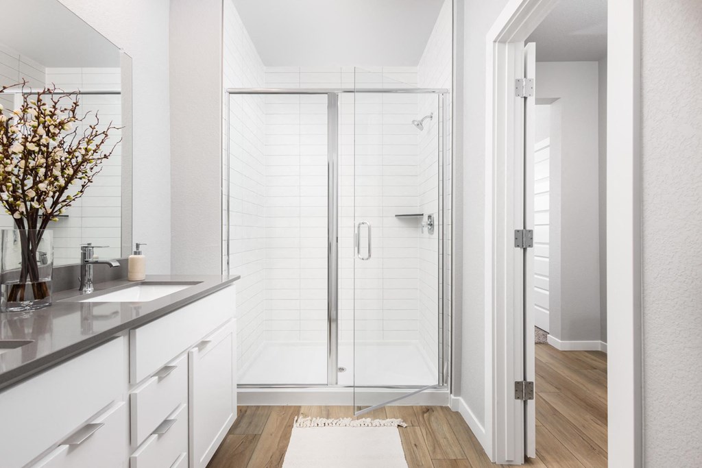 a white bathroom with a shower and a sink