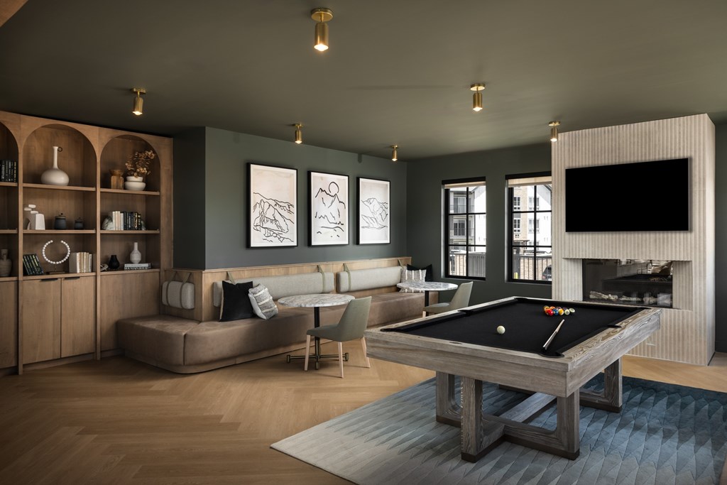 A pool table is in the middle of a living room.