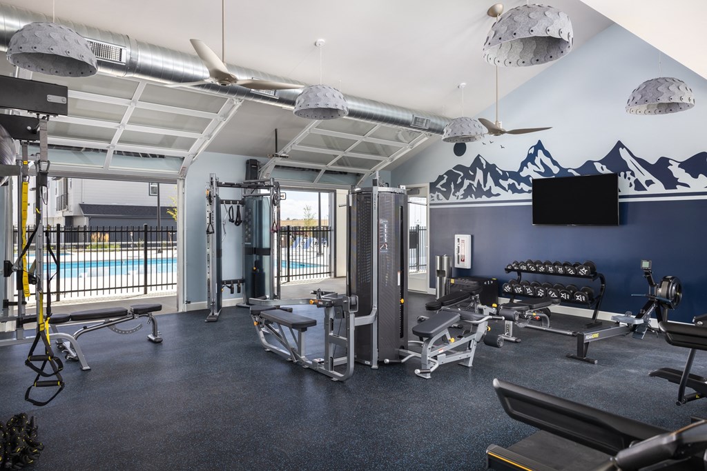 a gym with weights equipment and a view of a swimming pool