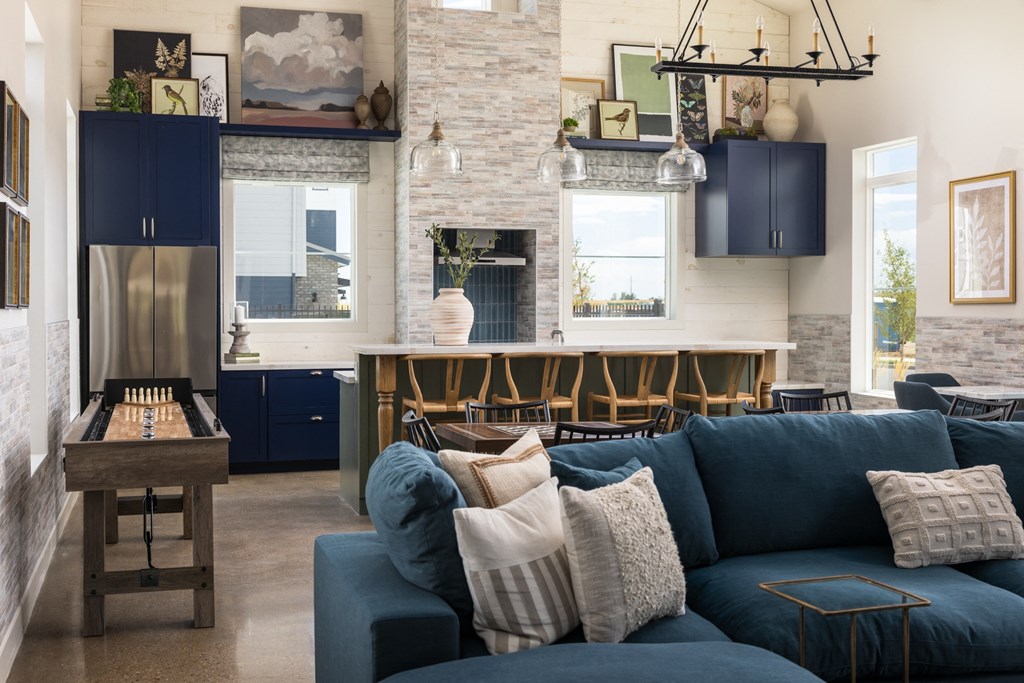 a living room with a blue couch and a kitchen with blue cabinets