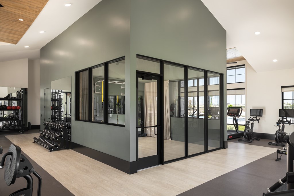 A gym with a variety of equipment including weights and treadmills.