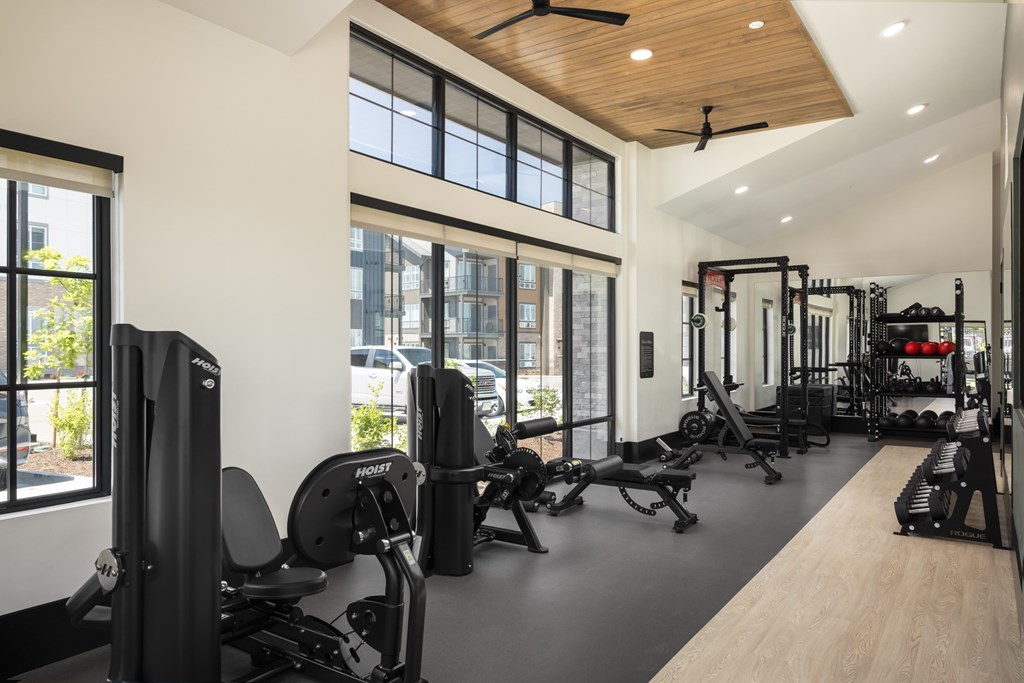 A gym with a variety of equipment including a weight machine, a bench press, and a squat rack.