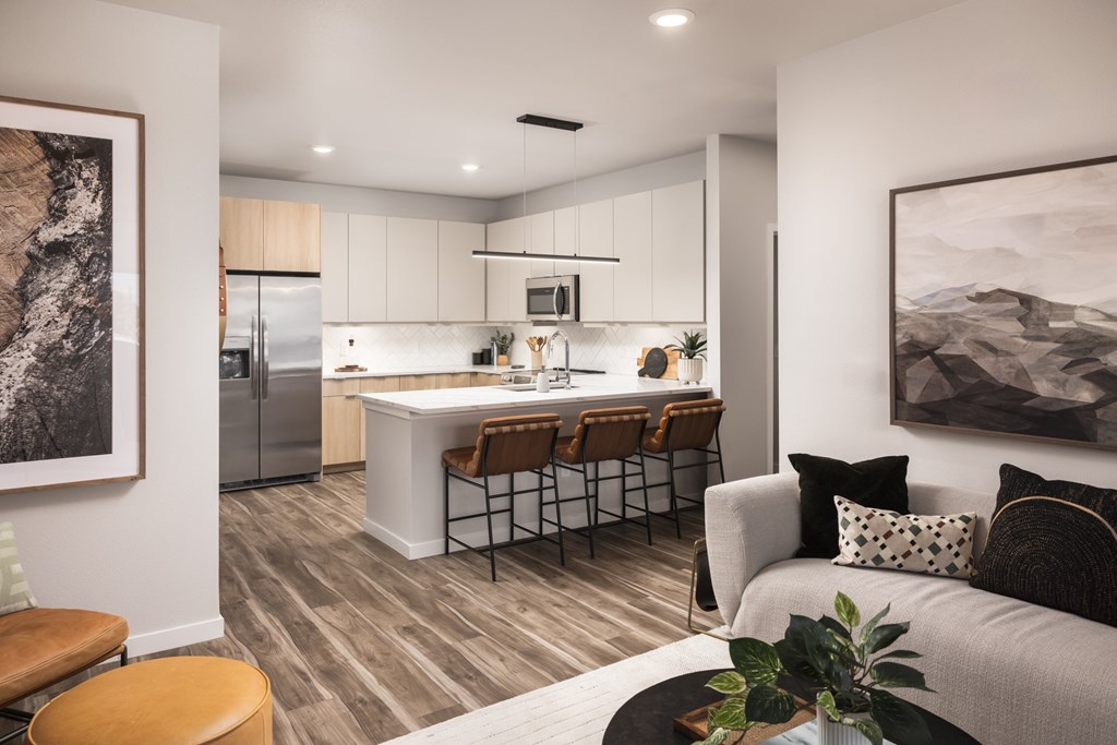 A modern kitchen with a bar area and a couch with pillows.