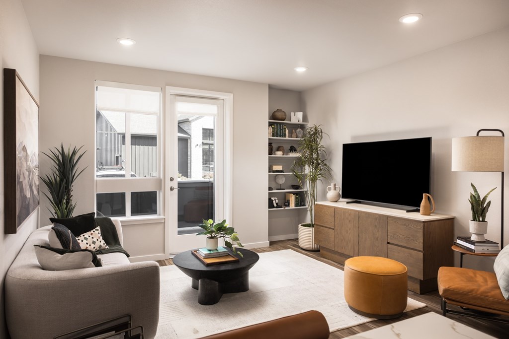 A modern living room with a grey sofa, a black coffee table, a wooden cabinet, and a flat-screen TV.
