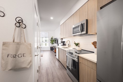 a kitchen with wooden cabinets and a tote bag on the wall