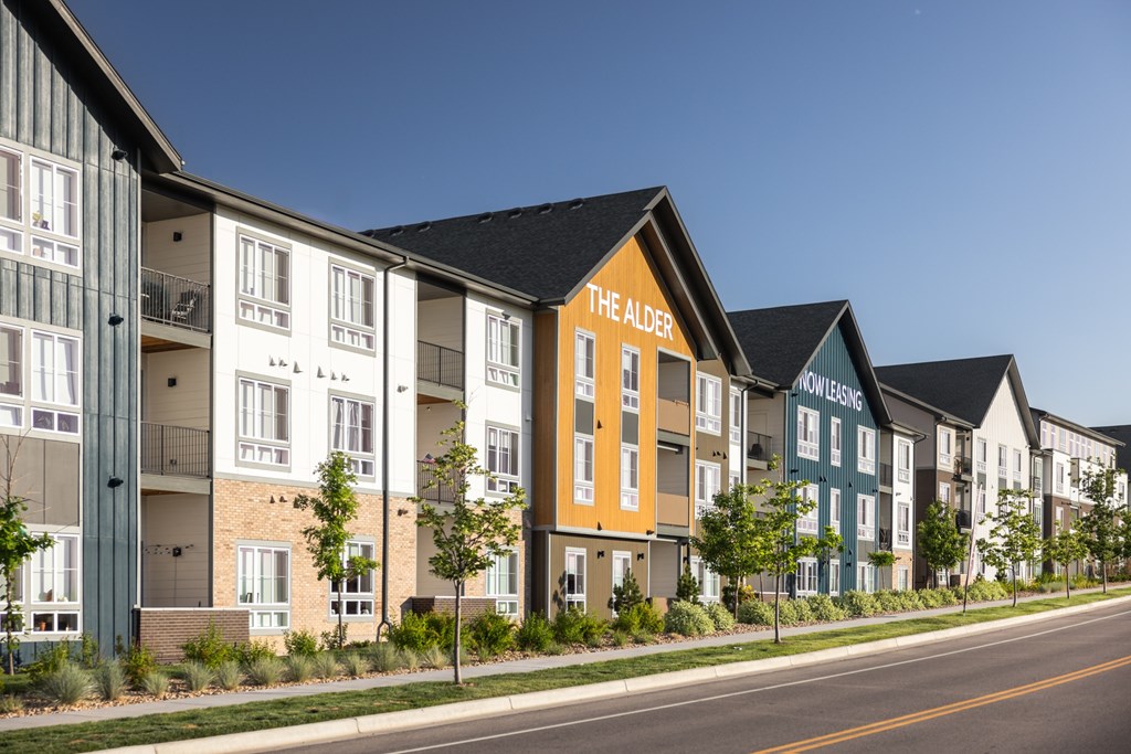Apartment buildings are lined up along a street.
