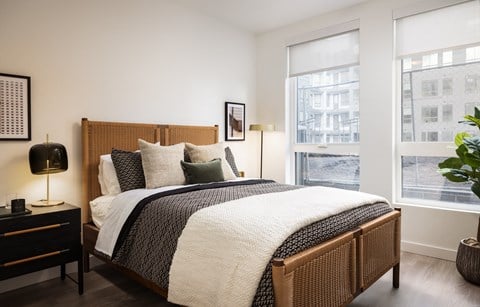 a bedroom with a bed and two windows
