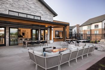 A patio with a fire pit and chairs.