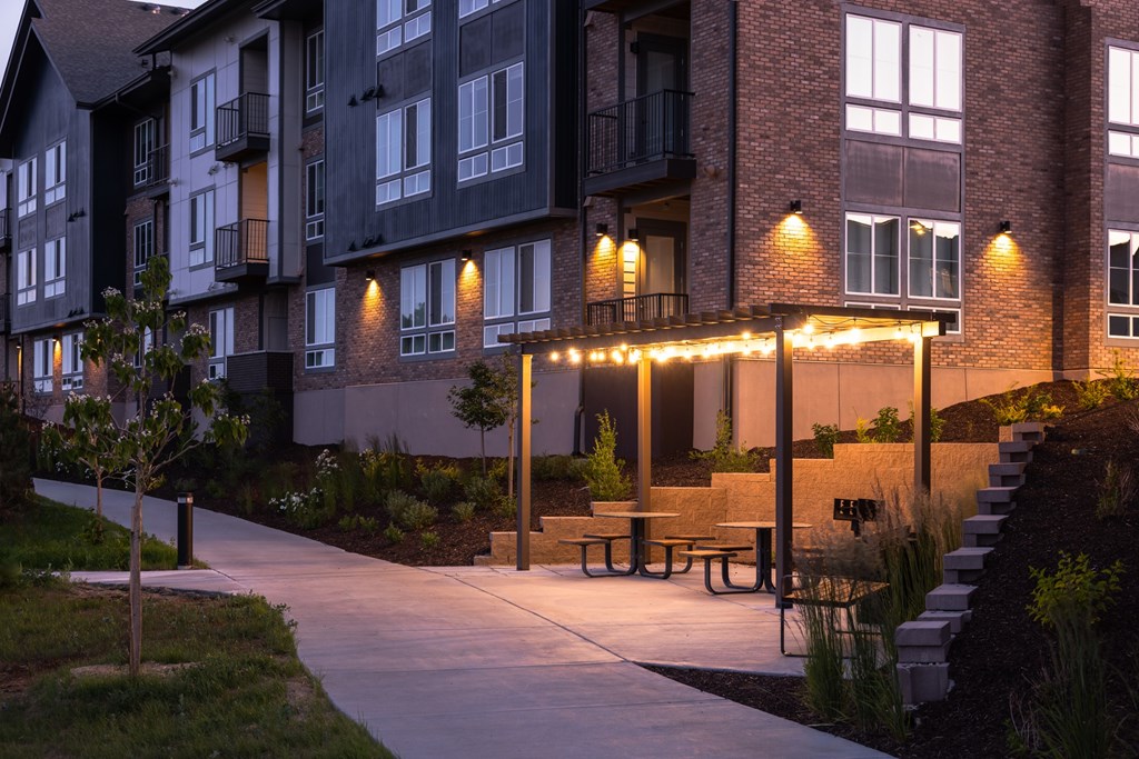A building with a balcony and a small patio with lights.