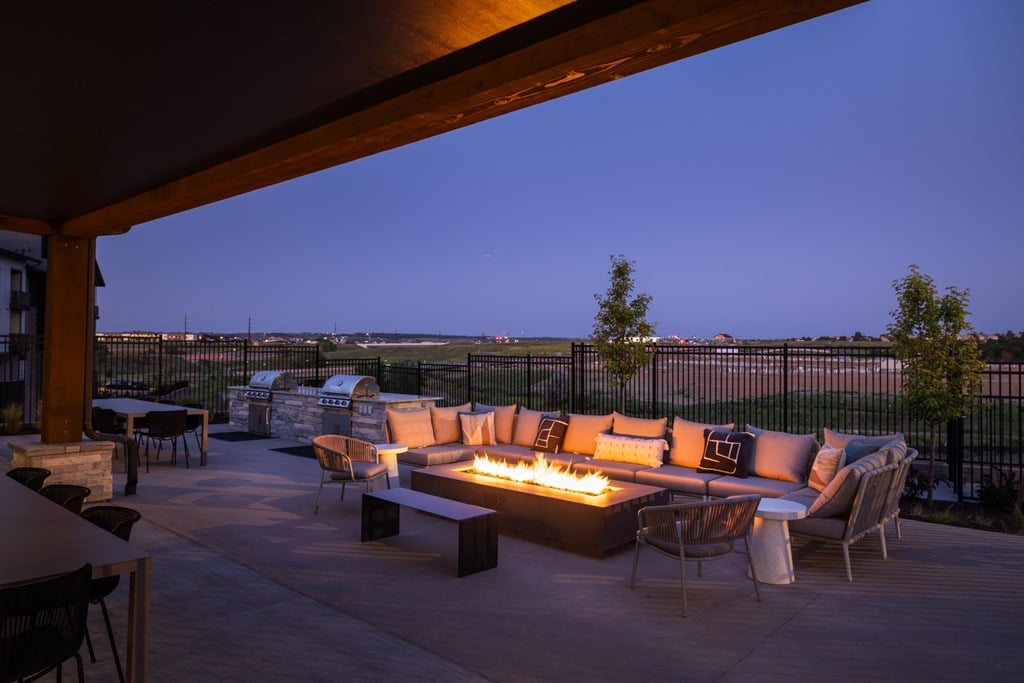 A patio with a fire pit and seating area.