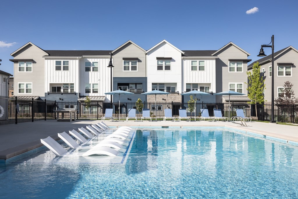 A swimming pool in front of apartment buildings.