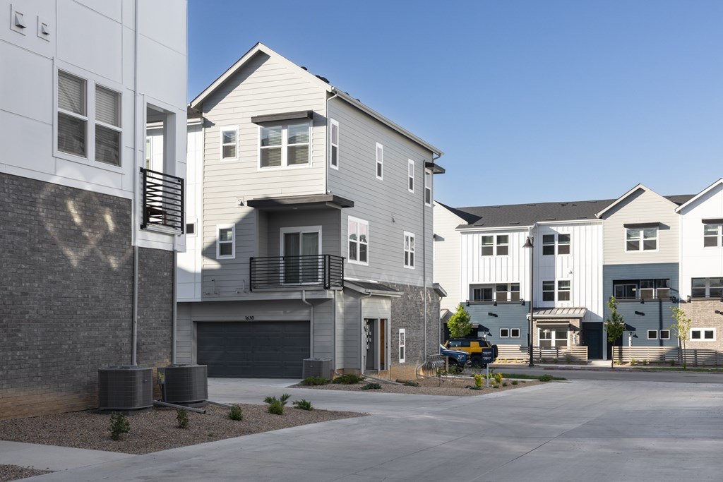 A row of modern houses with garages and driveways.