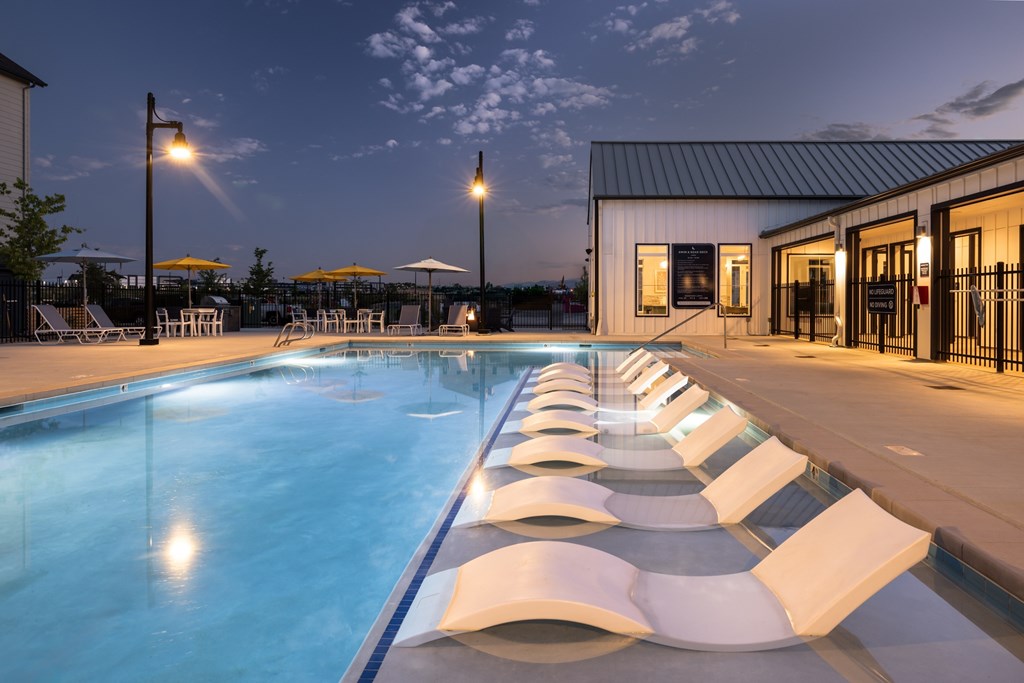 A pool with a row of sun loungers.