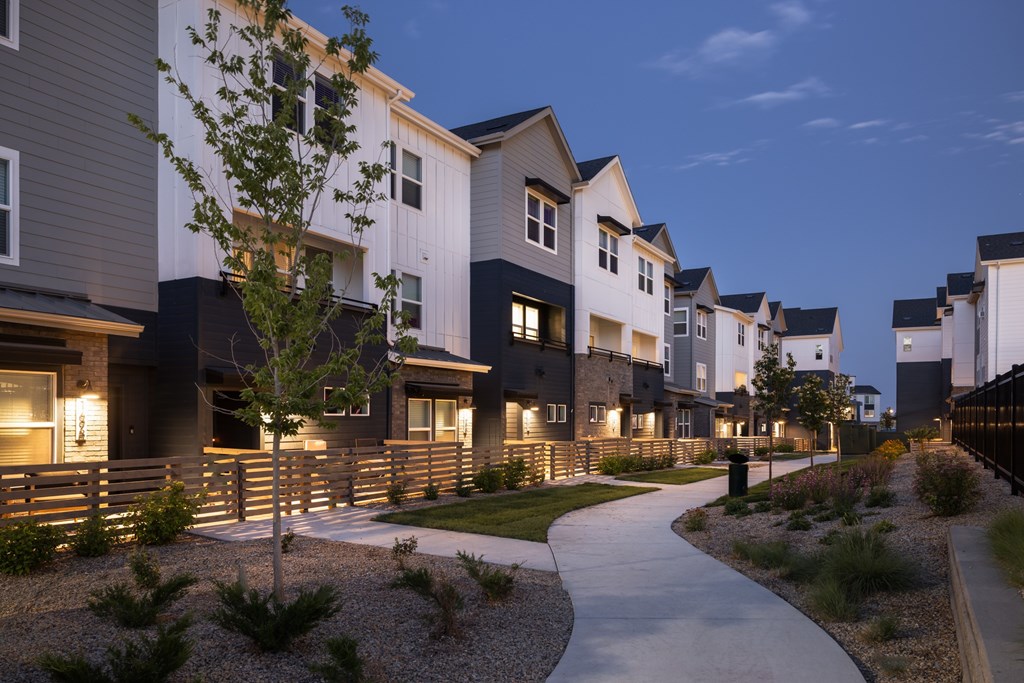 A row of modern houses with a pathway in front.