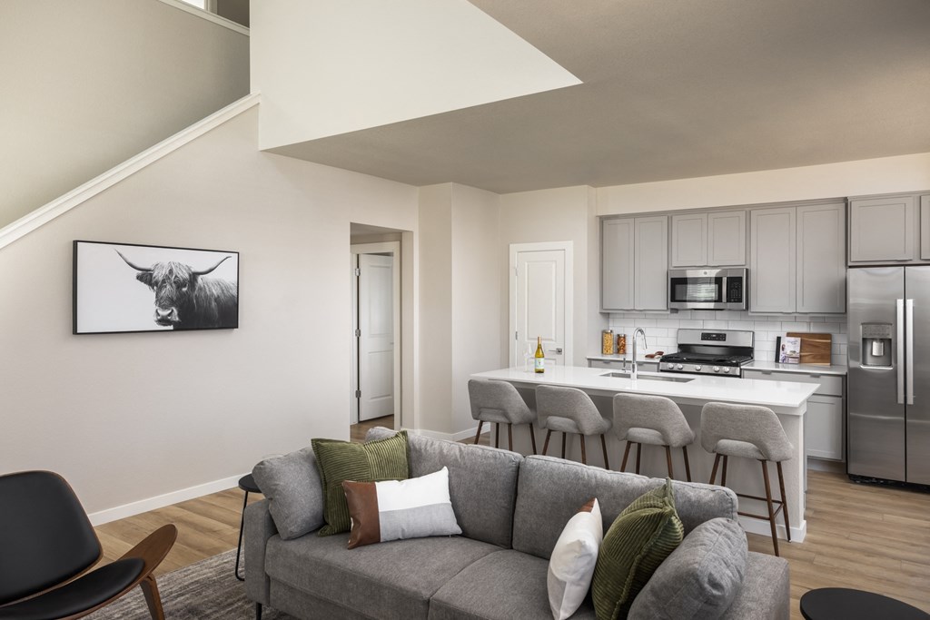a living room with a couch and a kitchen in the background