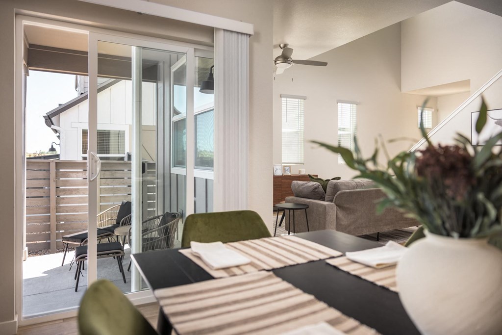 a dining room table with a vase of flowers