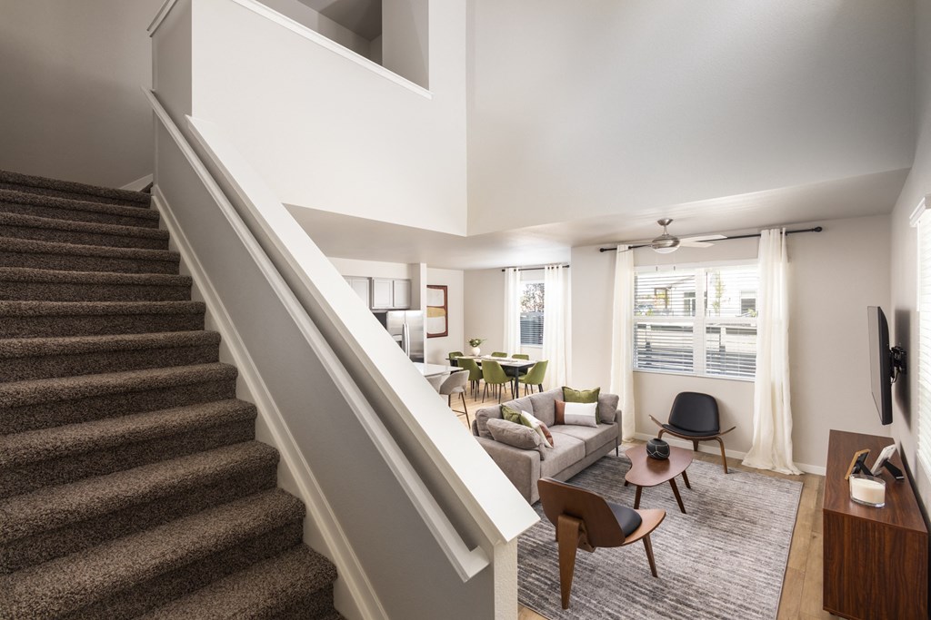 a living room with a staircase and a couch and a table
