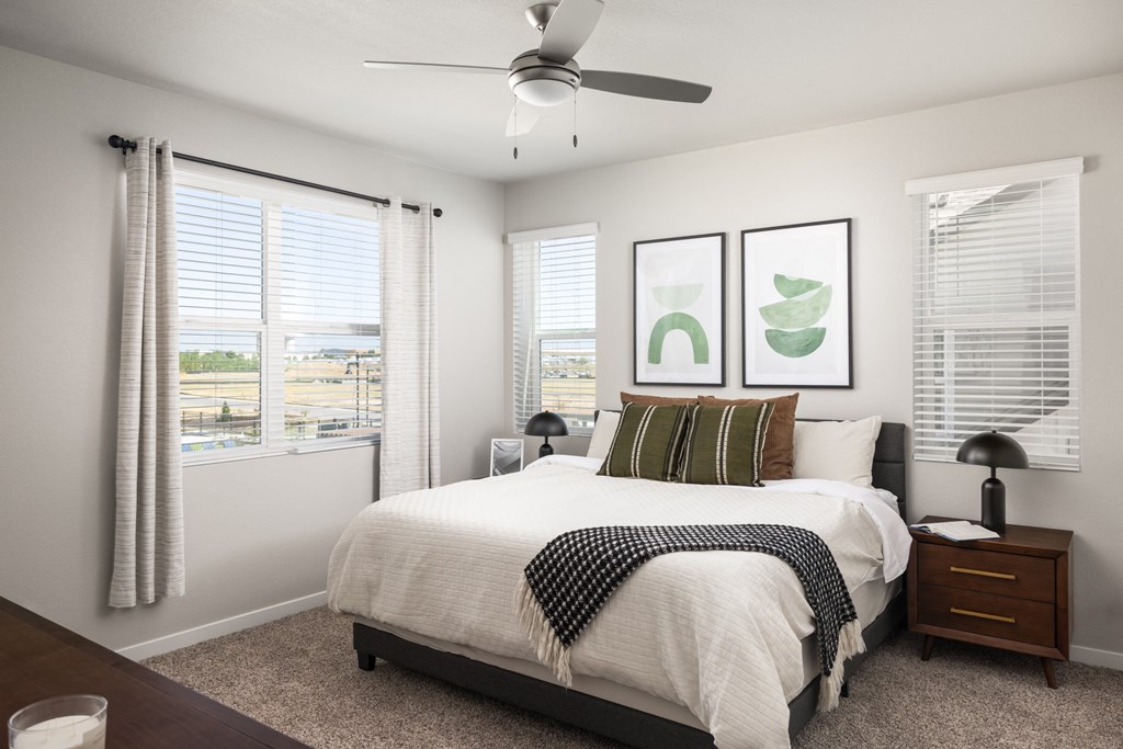 a bedroom with a large bed and a ceiling fan