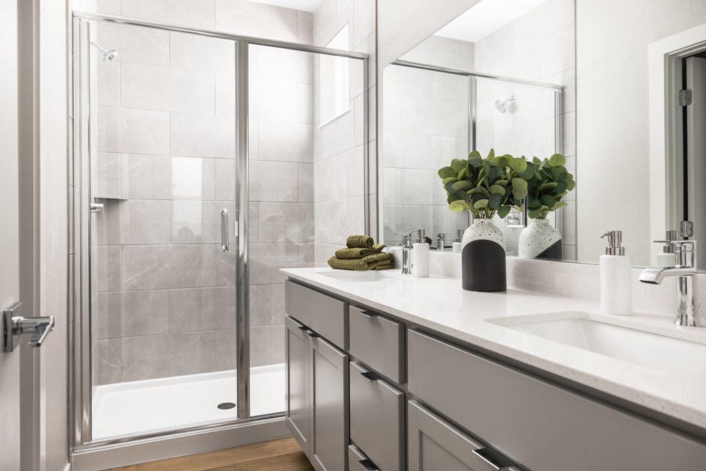 a white bathroom with a sink and a shower
