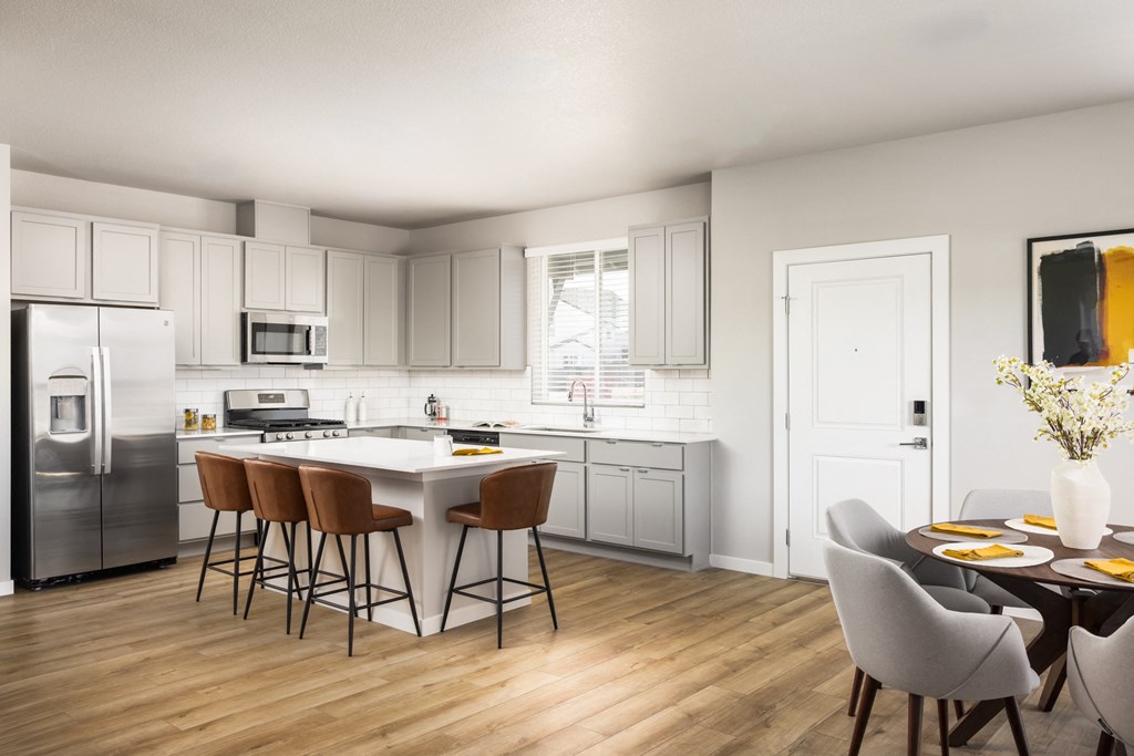 a kitchen and dining room with white cabinets and stainless steel appliances
