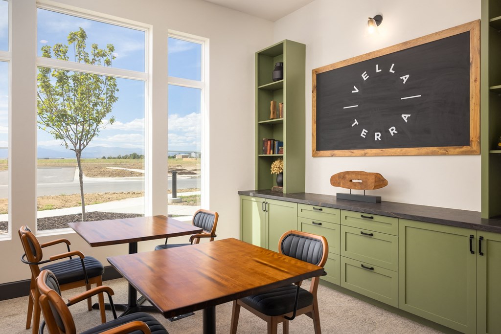 a classroom with a chalkboard and a table and chairs