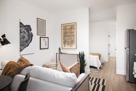 A living room with a grey couch and a black chair.