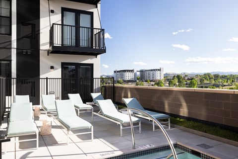 A balcony with chairs and a pool.