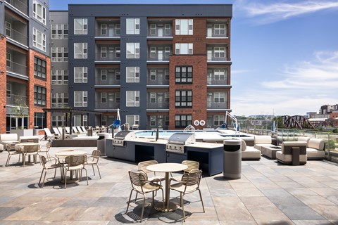 A rooftop patio with chairs and a hot tub.