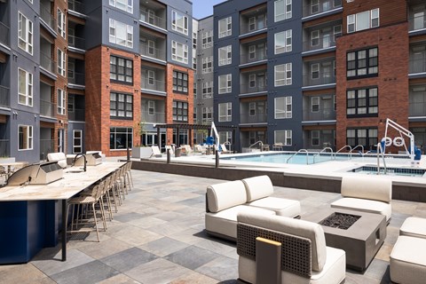 A large outdoor pool area with lounge chairs and a bar area.