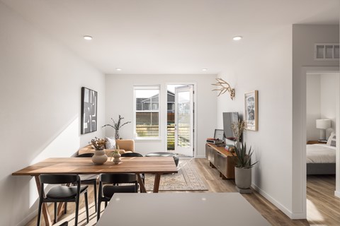 A modern dining room with a wooden table and chairs.