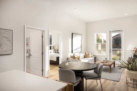 A modern living room with a grey sofa and a white table.