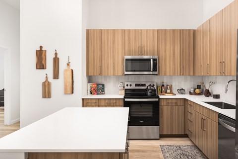 A kitchen with wooden cabinets and a white island.
