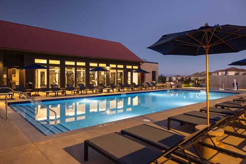 A pool with a red building behind it.