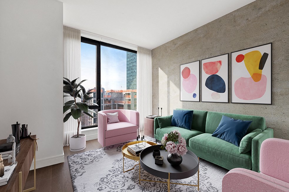 a living room with a green couch and pink chairs and a large window