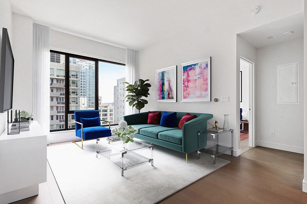 a living room with a green couch and a large window