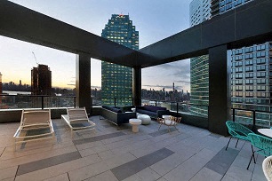 a large balcony with chairs and a view of the city