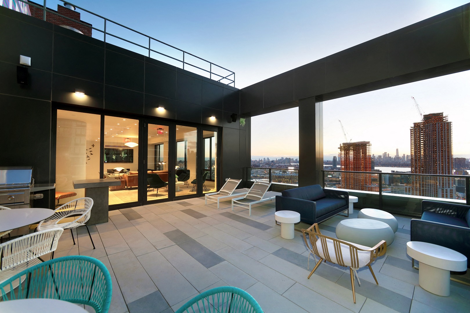a rooftop patio with chairs and tables and a view of the city