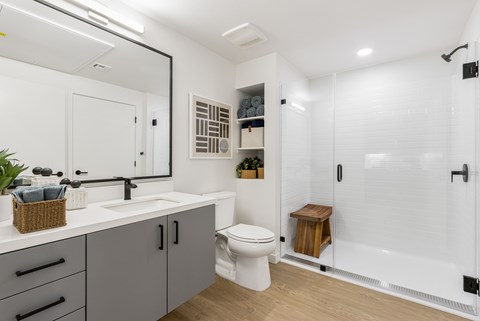 A white bathroom with a toilet, sink, and shower.